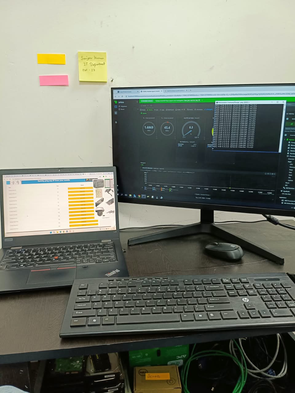 IT monitoring workstation with laptop, desktop monitor and system diagnostics