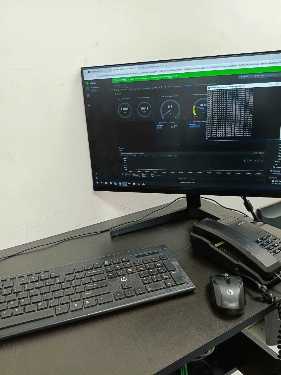 System monitoring setup with desktop monitor, terminal window and keyboard